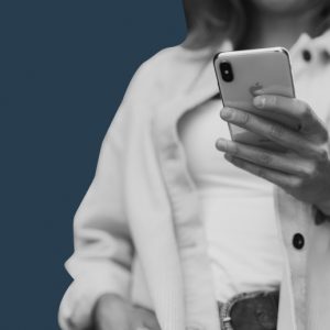 Woman using a smartphone against a dark blue backdrop