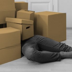 Person bried under a pile of cardboard boxes. Staying grounded during a move.