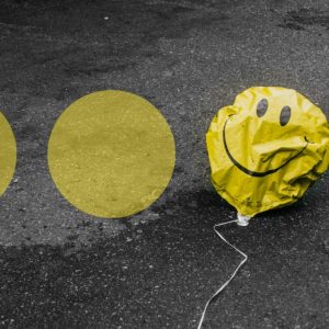 a row of yellow dots on pavement. One of them is replaced with a deflated, yellow smiley face balloon.Stigma Around Antidepressants Kept Me Trapped