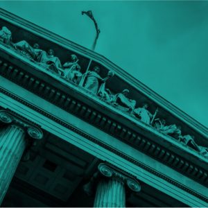 Green color overlay on a black and white photo looking up at a courthouse decorated with carved figures and pillars. Post-COVID regulations and telemedicine addiction care