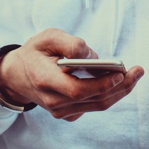 A man's hand using a smartphone