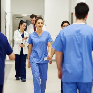 A hospital corridor bustling with medical professionals in scrubs.