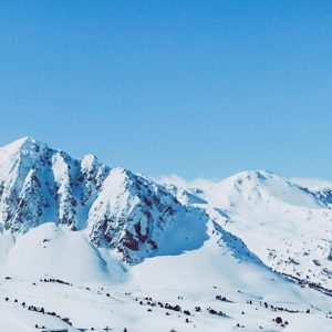 Snowy mountain peaks beneath a clear blue sky.