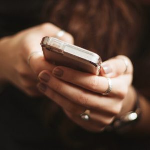 Close up on a woman's hands as she uses a smartphone