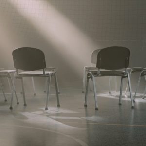 An empty circle of chairs in an empty gym.