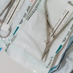 A tray of sterilized surgical tools, still in their wrapping.