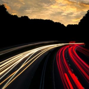 A long-exposure picture makes headlights and taillights of cars look like fast streaks of white and red.