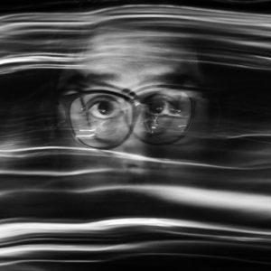 A blurry, smeared black and white photo of a man's face.
