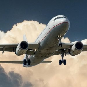 A passenger plane flying in front of a cloud