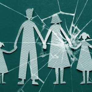 Paper cutouts of a family holding hands, with cracked glass centered over mother and daughter. Adult child of an alcoholic