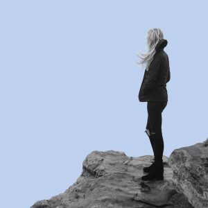 Woman alone on rocks. Does alcohol make anxiety worse?