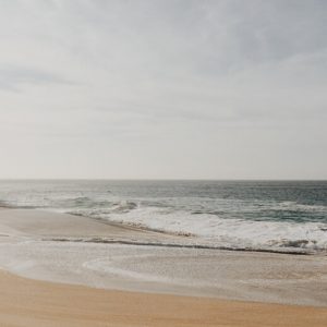 Peaceful, low contrast photo of an empty beach in Baja California, with waves breaking on the shore.