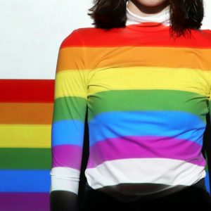 Woman in a rainbow sweater on a dark blue background. Being Open About My Bisexuality is a Huge Part of My Sobriety