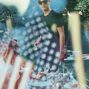 People at an outdoor barbecue. The image is overlaid with American flags.