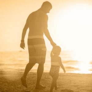Father and small child walking on the beach