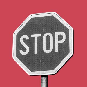 A grayscale STOP sign on a red background