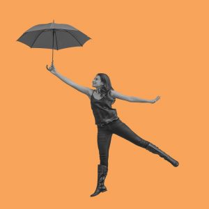 Woman with an umbrella, posed as though she's flying. Finding happiness after opioid addiction