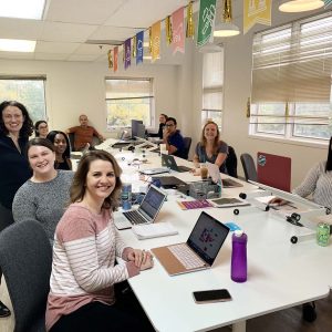 The Workit Health team working at laptops around a long conference table