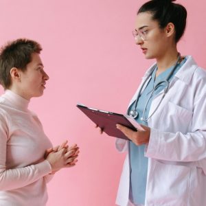 A tall female doctor speaks to a shorter female patient