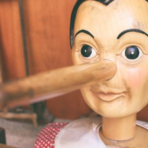 Pinocchio puppet with a long nose. Lies addicts tell ourselves.