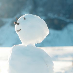 Happy snowman with its head tilted up as thoough enjoying the sun.