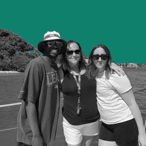A family of one African American man and two White women on a boat