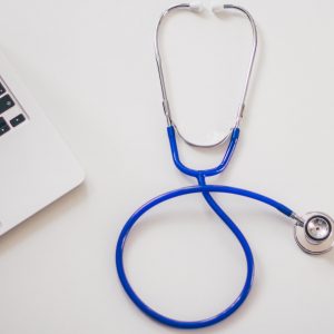 Stethoscope next to a laptop. Medication assisted treatment.