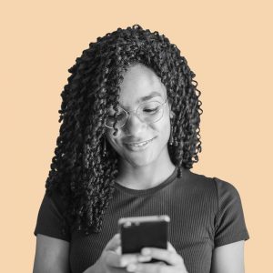 Young woman smiling at her smartphone. How Telemedicine for Addiction Treatment Works