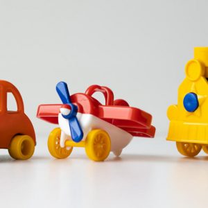 Brightly colored plastic toys: a car, an airplane, and a train. Traveling sober
