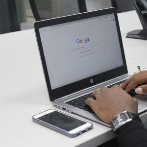 A black man on a laptop using Google