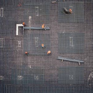 Aerial shot of construction workers laying rebar in a grid