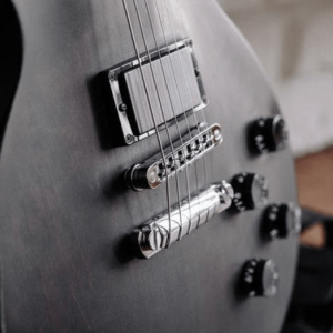 Close-up photo of the belly of a black electric guitar