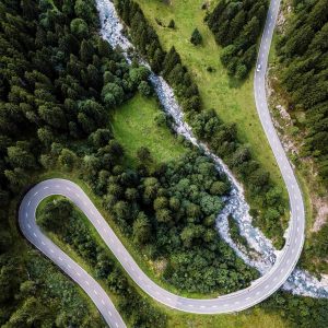 Aerial view of a road with a sharp, hairpin turn, winding across green landscape