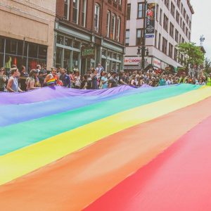 A rainbow flag fills the street at a Pride event