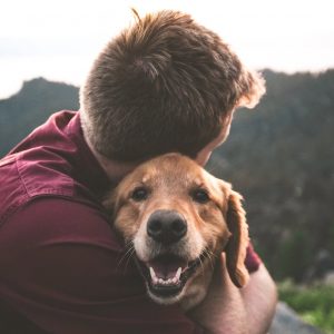 Man hugging a dog. Mental Health Awareness