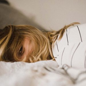 Woman lying face-down on a bed. Seasonal Affective Disorder in recovery