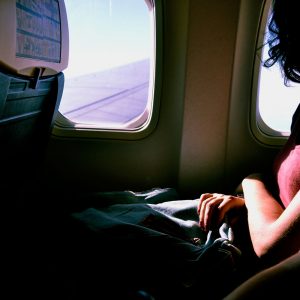 Woman looking out the window of an airplane. Business trips sober